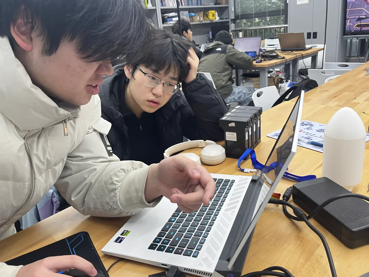 千里战队成员在实验室共同讨论技术问题