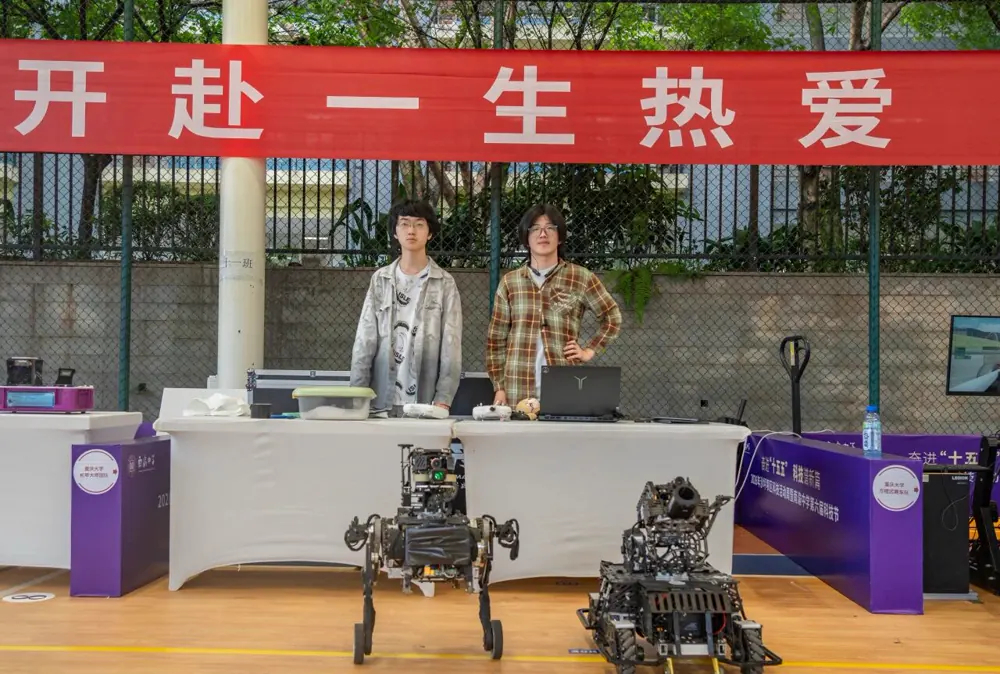 千里战队队员与机器人在南渝中学科技节展台合影