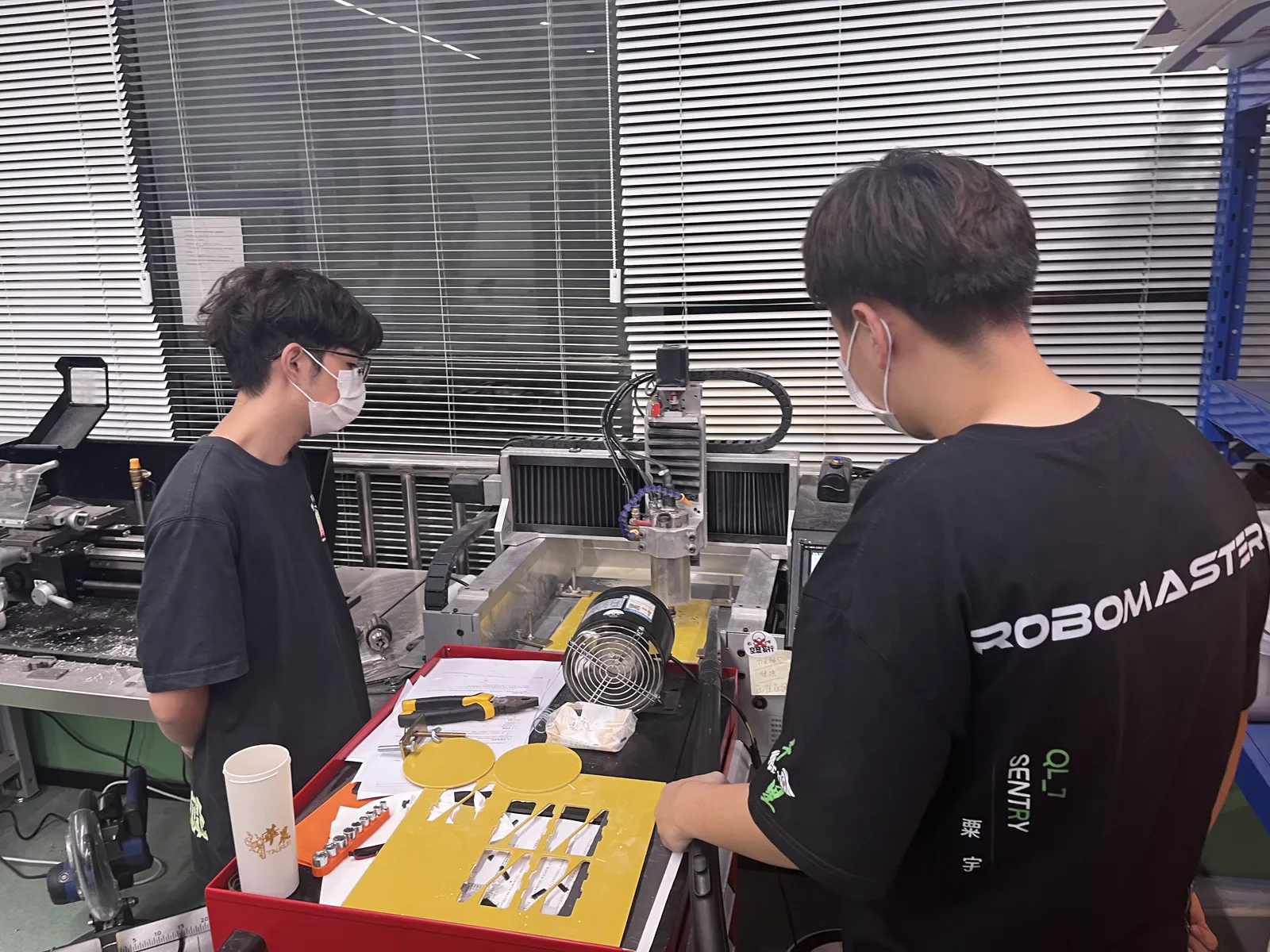 机械组队员在加工设备前完成零件加工